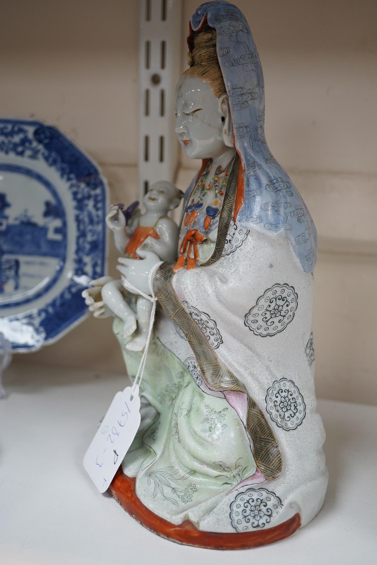 A Chinese enamelled porcelain group of Guanyin holding a child, Qianlong period